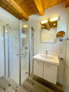 a bathroom with a glass shower and a sink at Am Hof Jungholz in Jungholz
