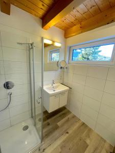 a bathroom with a glass shower and a sink at Am Hof Jungholz in Jungholz