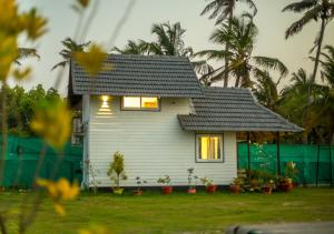 a small white house with a black roof at JC Den Kochi Villas by VOYE HOMES in Cochin