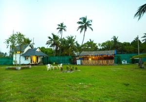 a building with tables and chairs in a field at JC Den Kochi Villas by VOYE HOMES in Cochin
