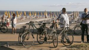 um homem parado ao lado de bicicletas na praia em Breathtaking seaview in Grado - Beahost Rentals em Lido