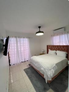 ein Schlafzimmer mit einem Bett und einem TV in der Unterkunft residencial garcia I apt 4 in La Romana