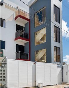 ein Gebäude mit einem weißen Zaun davor in der Unterkunft residencial garcia I apt 4 in La Romana