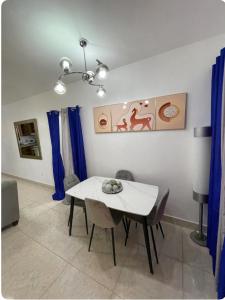 ein Esszimmer mit einem weißen Tisch und blauen Vorhängen in der Unterkunft residencial garcia I apt 4 in La Romana