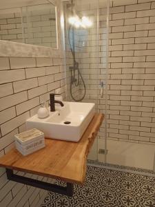 een badkamer met een witte wastafel op een houten tafel bij La casetta di rosario mondello in Palermo