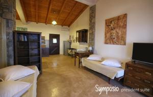 a room with two beds and a flat screen tv at Pyrgos Traditional Village in Agios Kirykos