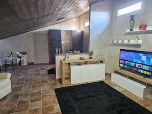a living room with a flat screen tv and a table at HOTEL BIJOUX in Pozzolo Formigaro