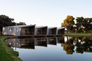 ein Haus an einem Fluss mit Reflexionen im Wasser in der Unterkunft Lakes Edge Villa 2 in Wilyabrup
