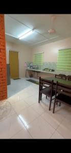 a room with two benches and a table in it at Nuha's Homestay Teluk Intan in Teluk Intan