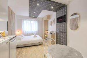 ein Schlafzimmer mit Bett und Tisch und eine Küche in der Unterkunft Blackwood-parking privé gratuit in Villeurbanne + 17 Fotos