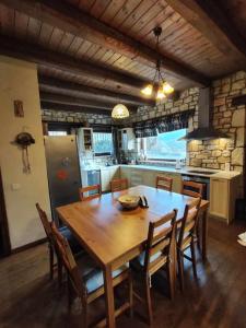 une grande cuisine avec une table et des chaises en bois dans l'établissement Erymanthos country home, à Kalavrita