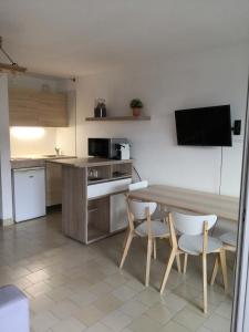 cocina con mesa, 2 sillas y barra en Studio à Hyères Port - Proche de toutes commodités, en Hyères