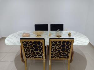 a dining table with two chairs and a white marble table at 30 R1 Single 1 Master Room in 3 bedroom apartment with attached washroom and balcony with fantastic sea view 30 R1 غرفة مفردة 1 ماستر في شقة 3 غرف نوم مع حمام ملحق وشرفة بإطلالة رائعة على البح in Ajman 