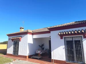 Casa blanca con techo rojo y 2 ventanas en Villa Rubio Vega, en Chiclana de la Frontera