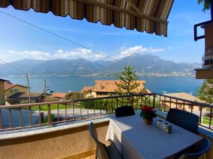 a table on a balcony with a view of the water at Sofia apartment near Bellagio in Lezzeno