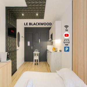 ein Schlafzimmer mit einem weißen Bett und einer Küche in der Unterkunft Blackwood-parking privé gratuit in Villeurbanne