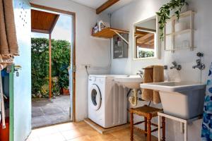 a bathroom with a sink and a washing machine at Casa La Palmera in Cala Figuera