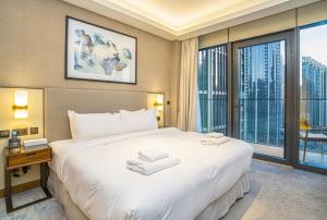 een slaapkamer met een groot wit bed en een groot raam bij Vacay Lettings Luxury Living Address Opera Downtown in Dubai