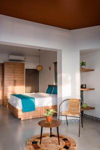 a bedroom with a bed and a table and a chair at Sunfun Beach House in Kannur