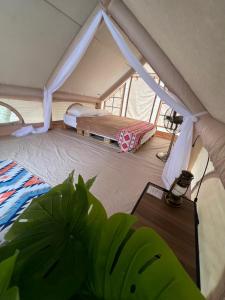 a room with a tent with a bed and a table at De Kampung Campsite in Rawang