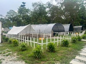 a white fence with tents in a field at De Kampung Campsite in Rawang