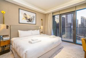 a hotel room with a large bed and a large window at Vacay Lettings Luxury Living Address Opera Downtown in Dubai