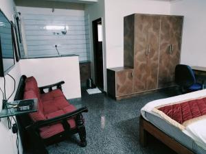 een kamer met een slaapkamer met een bed en een stoel bij Urban Express G Grand in Bangalore