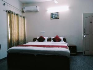 een slaapkamer met een groot bed met rode kussens bij Urban Express G Grand in Bangalore