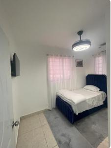 a small bedroom with a bed and a light at Residencial García 1 apt 3 in La Romana