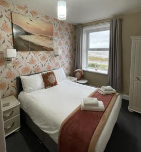 a bedroom with a large bed and a window at The Berkeley Morecambe in Morecambe