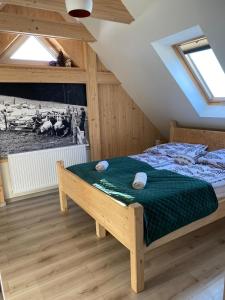 1 dormitorio con 1 cama con edredón verde en Apartament Nasze Poddasze, en Ciche