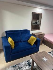 a blue couch with yellow pillows in a living room at Beach for Couples & Family - Hurghada - Free Fast Wi Fi in Hurghada