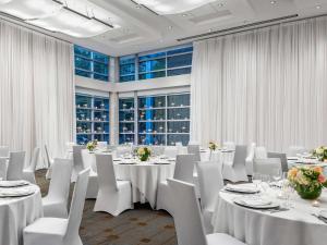 a conference room with white tables and white chairs at Sofitel Montreal Golden Mile in Montreal
