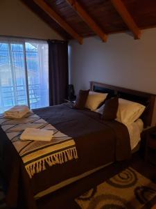 a large bed in a room with a window at Aysen Bike Cabañas in Puerto Aisén