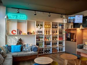 una tienda con sofá y una estantería de botellas de vino en Mercure Barcelona Condor, en Barcelona