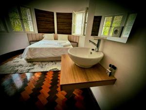 a bathroom with a sink and a bed at Guesthouse MALAGUETA INN II in Maputo