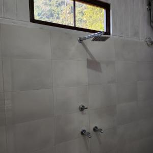 a shower with two faucets and a window in a bathroom at Aum 108 Retreat - Rishikesh Mountains in Rishīkesh