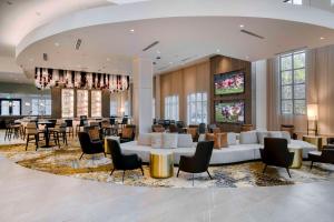 a lobby of a hotel with tables and chairs at Embassy Suites by Hilton Raleigh Durham Airport Brier Creek in Raleigh