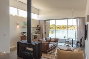 a living room with a fireplace and a couch at Edge Luxury Villas in Wilyabrup