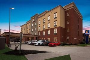 a large brick building with cars parked in a parking lot at Comfort Suites in Nashville