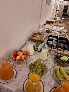 a table topped with bowls of fruit and juice at Pensiunea Tinelu Brașov sacele in Braşov