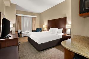 a hotel room with a bed and a television at Comfort Inn New Orleans Airport South in Saint Rose