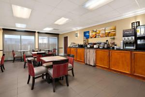 a restaurant with tables and chairs and a counter at Comfort Inn New Orleans Airport South in Saint Rose