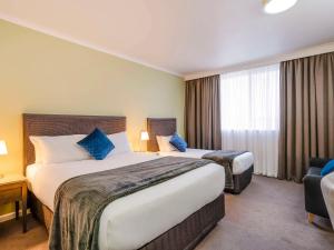 a hotel room with two beds and a window at Mercure Albury in Albury
