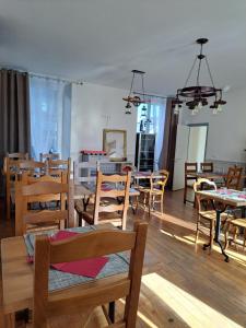 uma sala cheia de mesas e cadeiras de madeira em Au P'tit Gueul'ton em Les Aix-dʼAngillon