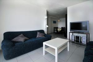 uma sala de estar com um sofá azul e uma televisão em Primera Linea con wifi y parking em Sant Antoni de Calonge