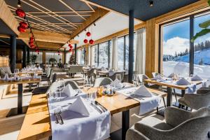 um restaurante com mesas e cadeiras com montanhas ao fundo em Alpin Peaks em Turracher Höhe