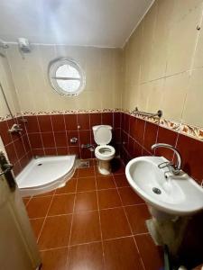 a bathroom with a toilet and a sink at High-Ceiling Cozy Appartment in Cairo