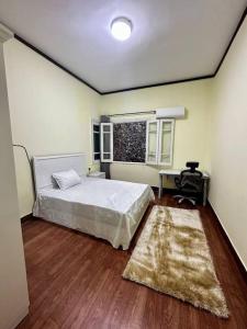 a bedroom with a bed and a desk and a window at High-Ceiling Cozy Appartment in Cairo