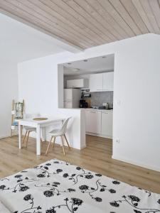 a white room with a table and a kitchen at Apartments Bassanese in Bled